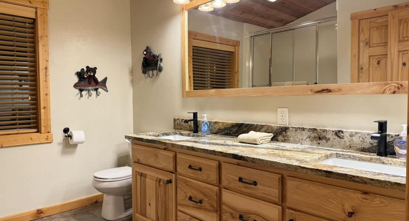 Shared bathroom upstairs with a shower tub combo, toilet, and sink vanity.