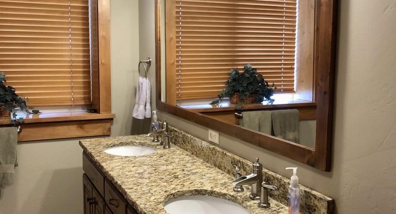 Basement ensuite bathroom with standing shower, sink vanity, and toilet.