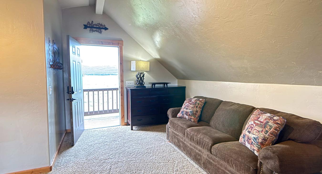 Unwind on the plush brown sofa directly beside the private entrance door, opening up to clean mountain air and stunning outdoor views.