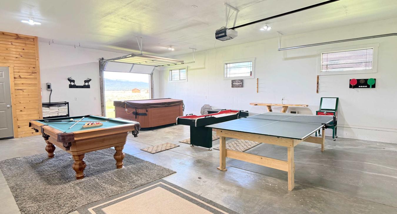 The expansive game room features a pool table, ping pong table, and shuffleboard—perfect for indoor entertainment and group fun.