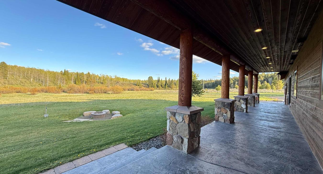 The view from the back porch to the yard and fire pit.