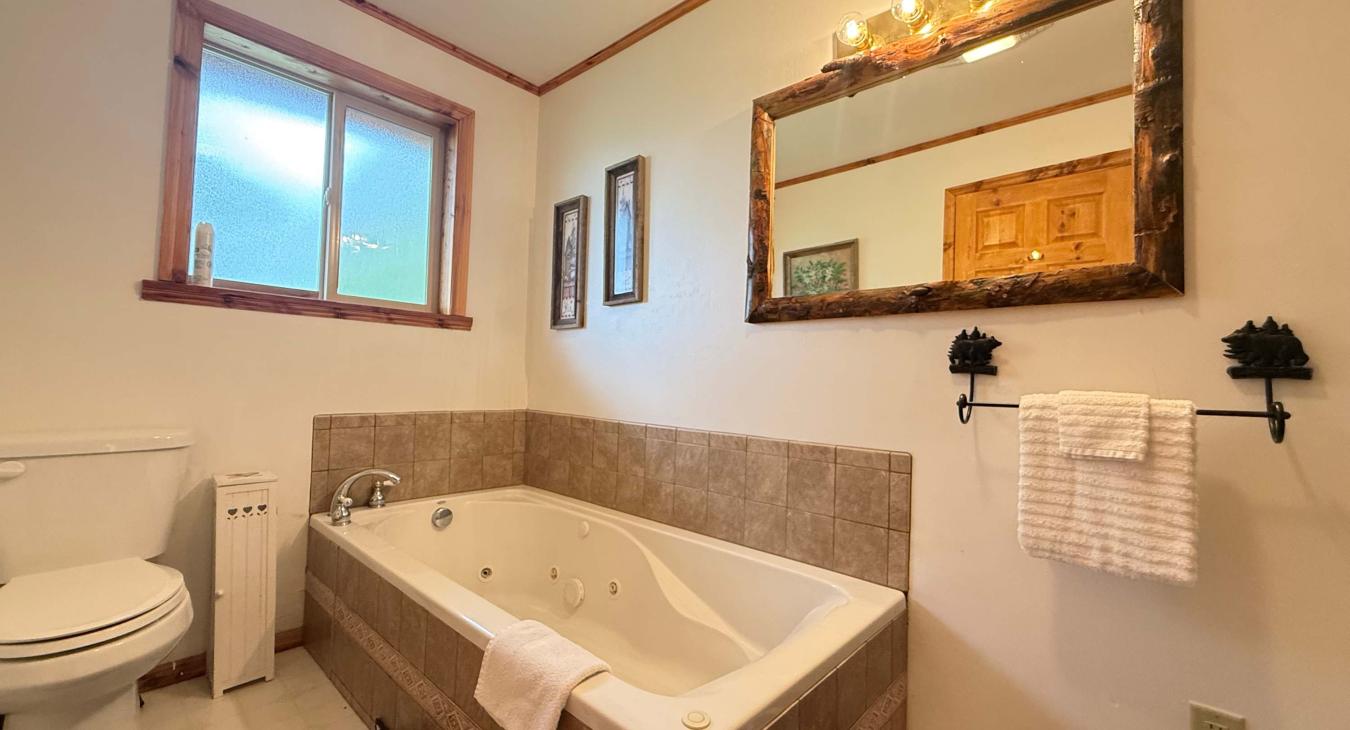 Bathroom is equipped with soaking tub, standing shower, toilet, and sink.