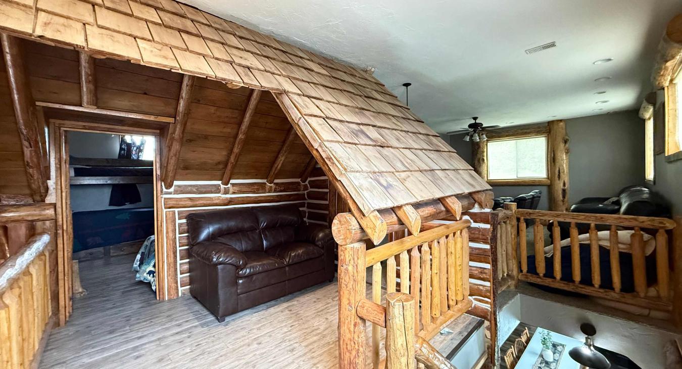Overlooking the main floor, this versatile upstairs loft beautifully showcases the cabin's incredible log craftsmanship and open architectural design.