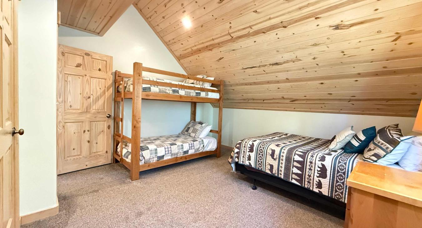 Bedroom #2 located upstairs with a Queen and a bunk bed. Large open room.