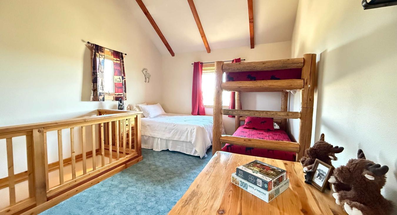 Open upstairs sleeping area with a queen bed and bunkbed.