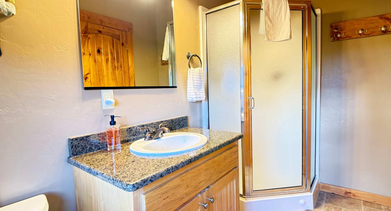 This private 3/4 bathroom above the garage includes a dedicated standing shower stall, ensuring guests have everything they need close by.