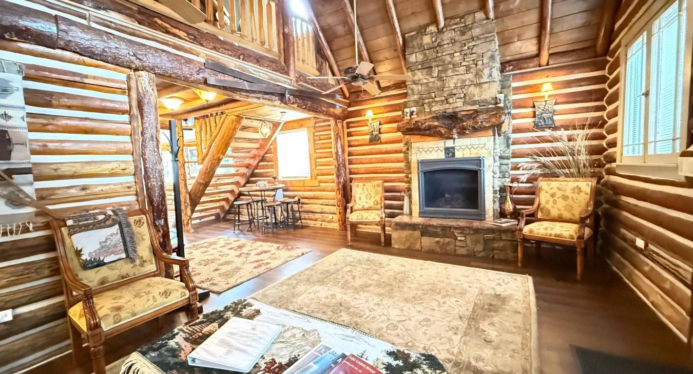 Gather around the grand floor-to-ceiling stone fireplace, featuring a convenient propane gas log insert and comfortable armchairs for a warm evening in.