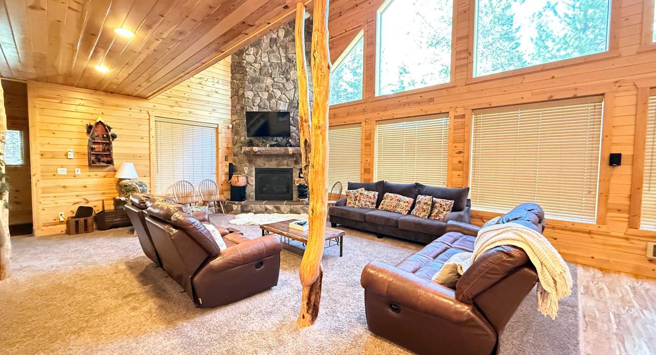 This breathtaking open great room boasts soaring vaulted ceilings and massive panoramic windows that perfectly showcase the beautiful natural surroundings.