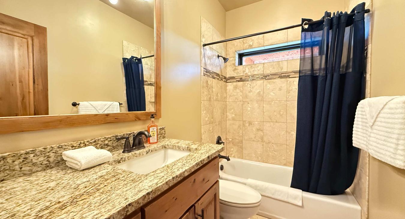 Hallway common bath with a tub and shower.