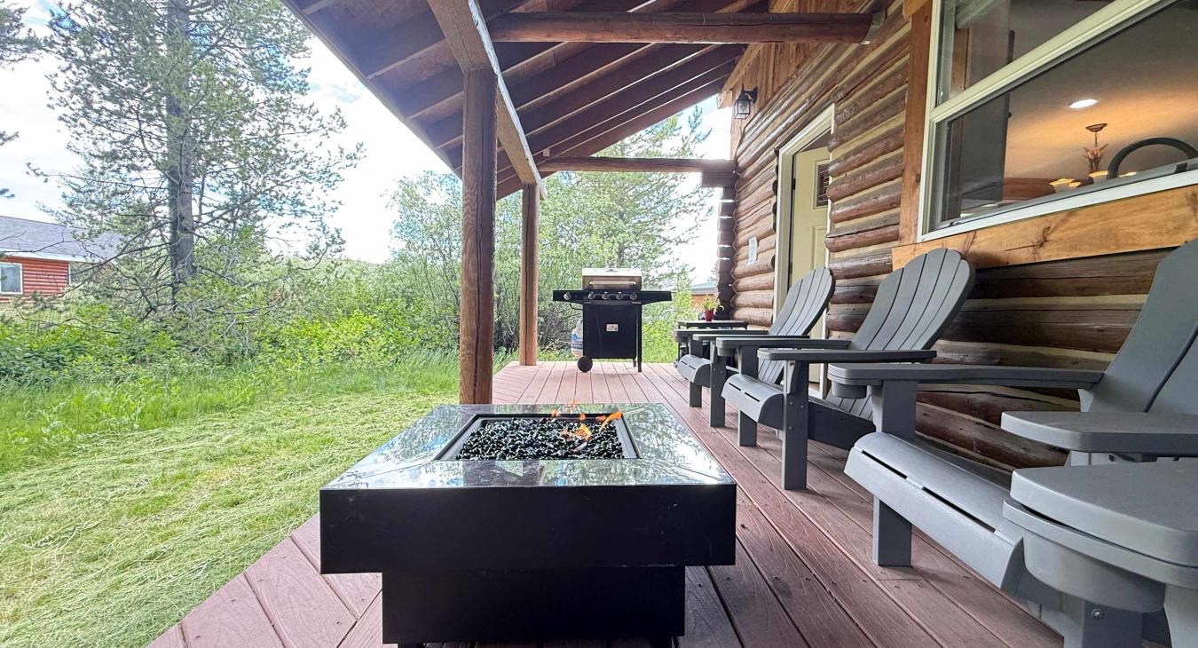 The covered outdoor deck perfectly combines relaxation and dining, featuring a modern propane gas fire pit table and a premium gas grill.