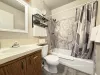 Full common bathroom. Tub and shower combo with shampoo, conditioner, and body wash provided. Toilet and sink vanity with storage underneath.