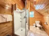 Bathroom upstairs with a standing shower, toilet, sink, and shelves for storage.