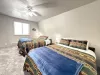This bedroom features 2 queen beds that can comfortably fit up to 4 guests. It also has a window overlooking the outside of the cabin and a 55 inch smart tv.
