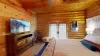 On one side of the room, there are French doors leading to a private deck. The deck, made of smooth wood, extends into the backyard, offering a peaceful space to unwind.