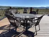 In the center of the deck, one large round table with seating are positioned for outdoor dining.