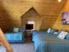 The upstairs bedroom in the cabin is a spacious, multi-functional retreat, designed to comfortably accommodate a larger group while maintaining the rustic charm of the cabin.