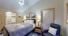 Second bedroom with a queen size bed, seating, and closet.
