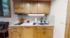 The compact kitchen featuring a stovetop, large sink, and plenty of cupboard space.