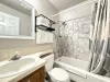 Full common bathroom. Tub and shower combo with shampoo, conditioner, and body wash provided. Toilet and sink vanity with storage underneath.