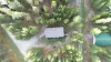 Arial view of the cabin and surrounding area. The cabin is surrounded in pine trees.