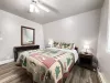 This bedroom features 1 queen bed that will comfortably sleep 2 guests with luggage racks for your bags. It also has a window overlooking the beautiful scenery of the cabin.
