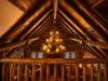 Look up to admire the incredible log craftsmanship and the grand antler-style chandelier, casting a warm, golden glow across the soaring vaulted ceilings.