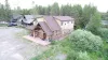 This beautiful aerial drone shot showcases the full scale of the authentic log home and the private, forested surroundings of the property.