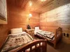 Dual twin bedroom with a tv and gaming system.