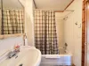 Shared bathroom on the main level with shower tub combo, toilet, and sink.