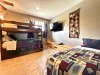 The ultimate kids' retreat comes complete with a large wall-mounted Smart TV and a long wooden bench setup for comfortable viewing.