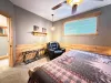 The charming Queen room offers ample space, complete with luggage racks, cozy log accents, and easy access to the hallway.