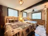 Perfect for families or groups, the third spacious bedroom offers two comfortable log-framed Queen beds side-by-side with cozy matching quilts.