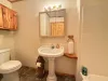 Shared bathroom on the main level with shower tub combo, toilet, and sink.