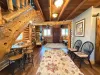 A charmingly designed open floor plan features a rustic log staircase with a cozy bonus seating nook nestled perfectly underneath.