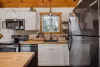 Kitchen with appliances, pots and pans, basic cooking essentials, dishes, and utensils.
