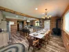 Gather everyone together at the grand dining table, beautifully lit by an elegant country chandelier and warmed by the cozy wood-burning stove nearby.