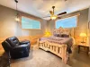 Unwind in comfort with the room's plush leather reclining armchair, ideal for relaxing under the soft glow of the cabin ceiling fan.
