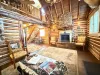 Gather around the grand floor-to-ceiling stone fireplace, featuring a convenient propane gas log insert and comfortable armchairs for a warm evening in.