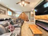This impressive theater room features multiple plush leather reclining chairs, a large wall-mounted Smart TV, and a cozy electric fireplace.