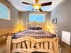 This peaceful bedroom features a beautifully crafted log-framed king bed, warm bedside lighting, and a rustic wilderness quilt.
