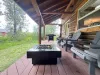 The covered outdoor deck perfectly combines relaxation and dining, featuring a modern propane gas fire pit table and a premium gas grill.