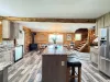The beautifully designed kitchen blends rustic log charm with modern convenience, complete with high-end stainless steel appliances and smooth hardwood-style flooring.