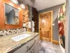 The beautiful 3/4 bathroom features a stunning granite-top vanity with rustic wood framing.